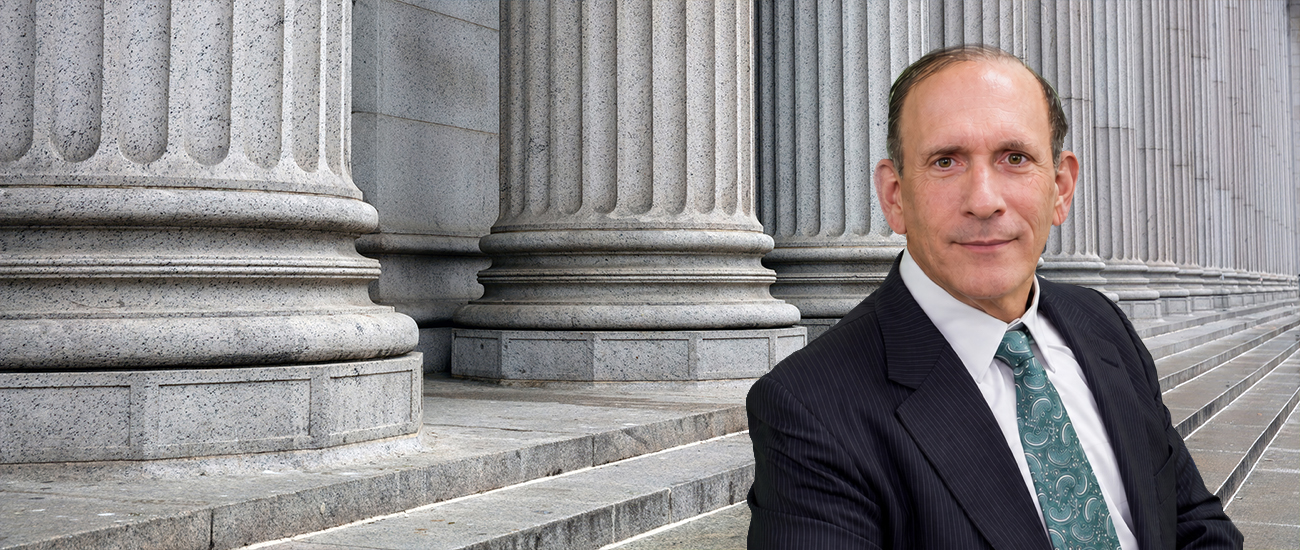 Attorney Dale Kasofsky stands before the stone columns of a courthouse.