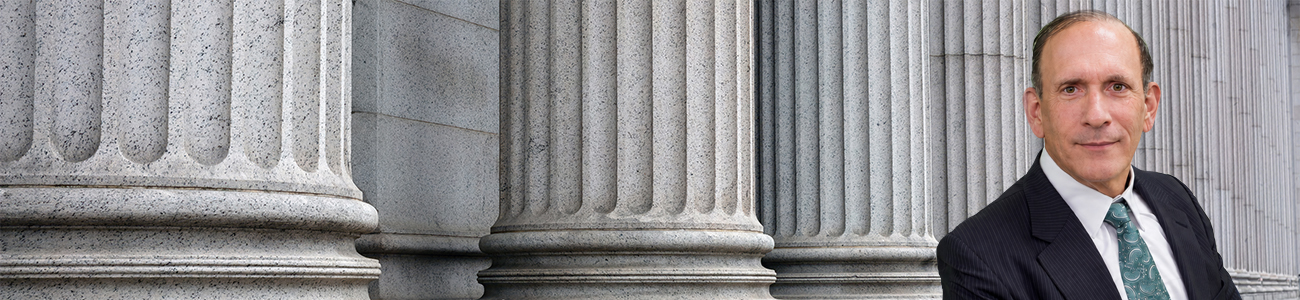 Attorney Dale Kasofsky stands before the stone columns of a courthouse.
